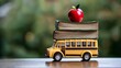 © Sami_Art - A toy school bus carrying a stack books with a red apple on top, symbolizing creativity and education