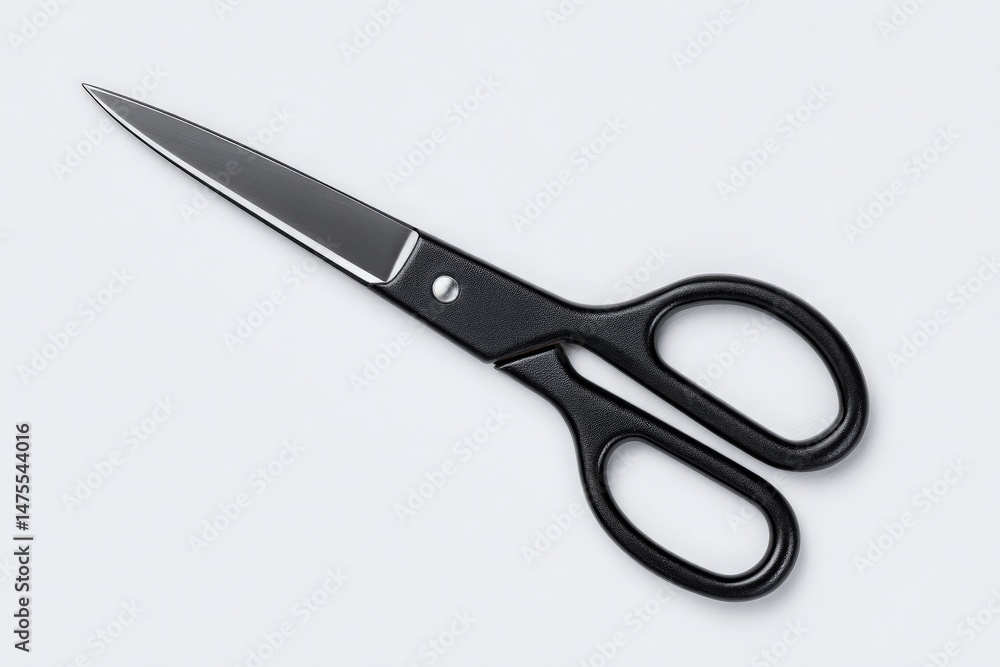 A pair of sharp black scissors rests on a smooth light gray surface, showcasing its sleek design and shiny blade, ideal for cutting materials in various DIY projects.