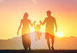 © kieferpix - Parents showing child love and support concept. Happy family silhouettes bonding playing in the sunset