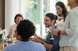 © wavebreak3 - Friends laughing and enjoying drinks together at wedding reception indoors