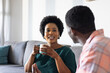 © wavebreak3 - Friends enjoying coffee and conversation at home, sharing laughter and stories