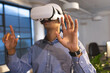 © WavebreakMediaMicro - Businessman using VR headset in modern office, interacting with virtual environment