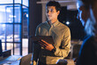 © WavebreakMediaMicro - Young professional using tablet in modern office during night meeting