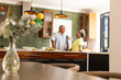 © wavebreak3 - Senior couple enjoying conversation in modern kitchen with festive balloons