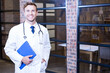 © WavebreakMediaMicro - Standing 30s male doctor holding clipboard with stethoscope in office hallway, copy space