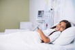 © wavebreak3 - Smiling female child patient resting on pediatric ward bed with infusion pump tubing, copy space