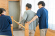 © buritora - 手すりを使い歩行訓練するシニア男性と介助する作業療法士,理学療法士の男性スタッフ