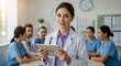 © AlfaSmart - Medical professional standing with tablet in meeting room for hospital teamwork