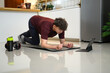 © Prathankarnpap - Young man doing plank exercise at home while following a workout video on a tablet