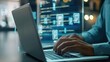© MINHOO - A man is typing on a laptop with a screen displaying a computer program