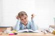 © New Africa - Tired little girl doing homework at table indoors