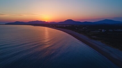Wall Mural - Ocean sunset aerial view has mountains in the background at dusk. It's perfect for travel, relaxation, or inspirational nature content.