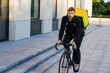 © makedonski2015 - Portrait of a bicycle courier against the background of modern districts in the city. Food and grocery delivery