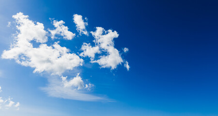 Wall Mural - a serene blue sky adorned with white, fluffy clouds floating tranquilly