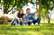 © Prathankarnpap - daughter sitting on grass and enjoying nature together at a peaceful campsite
