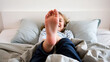 © Cynthia - smiling girl lying in bed feet up