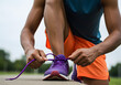 © Zheva - Person tying running shoes outdoor