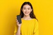 © Dzikrul Husnani - Smiling Woman Holding Smartphone: Vibrant Yellow Minimalist Portrait