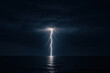 © Eing - Lightning bolt strikes ocean at night, illuminating dark storm clouds and reflecting on water surface with dramatic intensity