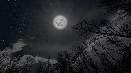 Wall Mural - a moon moving in the night sky with stars and clouds