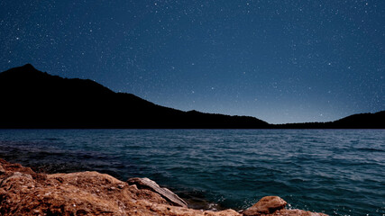 Wall Mural - sunrise over the sea with gentle waves and fading stars in a peaceful, dreamy atmosphere