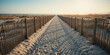 © Choo NSK - 3D illustration of symmetrical beach walkway with wooden fences and footprints in golden sand under soft sunset light, tranquil coastal landscape scene