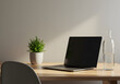 © Ramdhaniyah - Laptop on wooden desk with plant and water bottle in natural light