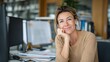 © Art - Woman smiles at desk in office environment with computer and office supplies.