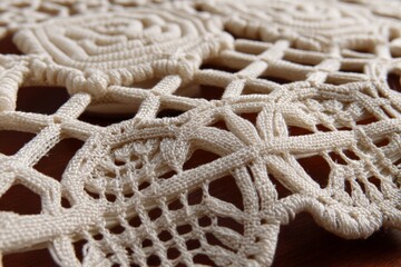 Poster - Intricate lacework featuring floral patterns on a wooden surface captured in soft lighting