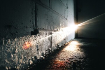 Aufkleber - Light filtering through a crack in the wall creates an atmospheric effect in a dimly lit space