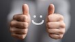 © KohXD - Person's thumb with a smiley face drawing representing positive consumer confidence in spending and engagement