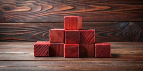 Aufkleber - A pyramid structure constructed from richly hued wooden blocks rests on a dark brown wooden surface