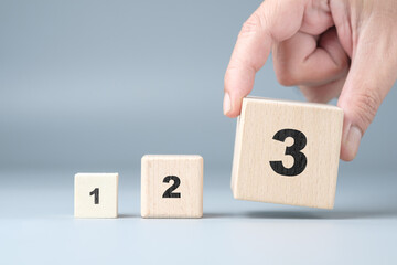 Fototapete - Hands arrange wooden cubes numbered 1 2 3 in order from smallest to largest, importance of following the steps