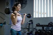 © FotoAndalucia - Woman in gym training with dumbbells