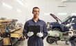 © Ljupco Smokovski - African american car mechanic holding a clipboard at a garage
