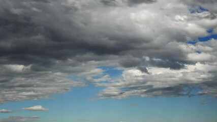 Wall Mural - Time-lapse of white to gray clouds and bright blue summer sky moving away from the viewer