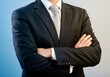 © NoorStockHouse - a businessman with his arms crossed, wearing a dark suit and a light gray tie.
