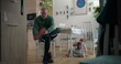 © Marco - Father tying boots while a young boy sits on the floor holding a toy car, in a cozy family dining room with wooden flooring and decorative elements
