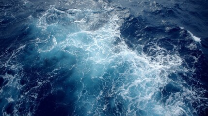 Poster - Aerial view captures the deep blue ocean showcasing dynamic wave patterns and gentle reflections of the sky, highlighting nature's beauty during the day