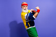 © deagreez - Confident senior man in retro inspired activewear flexing with enthusiasm against a vibrant purple background