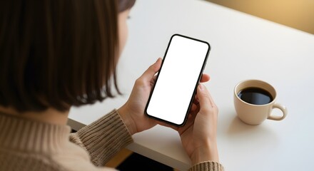 Woman Holding Smartphone with Blank Screen Next to Coffee