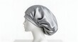 © MariaMedeiros - A silver satin bonnet is seen on a mannequin head, providing nighttime hair protection.