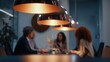 © ngstock - Stylish Close-Up Shot of a Team Meeting in Sync Under Modern Pendant Lighting in a Contemporary Office Setting
