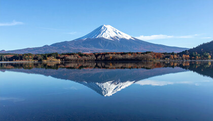 Wall Mural - Majestic snowcapped mountain reflecting in calm lake, surrounded by autumn foliage and clear blue sky, creating serene and picturesque landscape