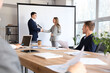 © Pixel-Shot - Business partners shaking hands near projector screen in conference room