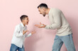 © Pixel-Shot - Angry father with his son squabbling on pink background