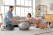 © Pixel-Shot - Sporty pregnant couple training with fitball at home