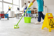 © Pixel-Shot - Female janitor mopping floor and her team cleaning in office