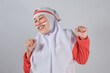 © Alpian Ahmad Nurdin - Smiling Muslim woman in hijab with clenched fists celebrating national pride with Indonesian flag face paint, radiating joy, confidence, and cultural identity in expressive pose