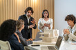 © Art_Photo - Architects engineers collaborating on building design project in modern office, diverse team of professionals female muslim architect and male engineers discussing architectural model of structure
